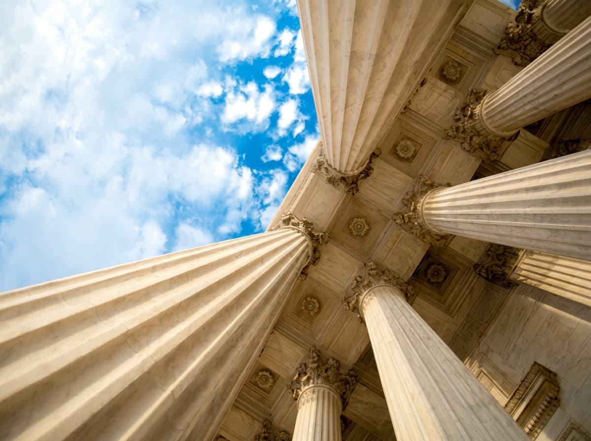 Classical stone columns of a courthouse seen from below.