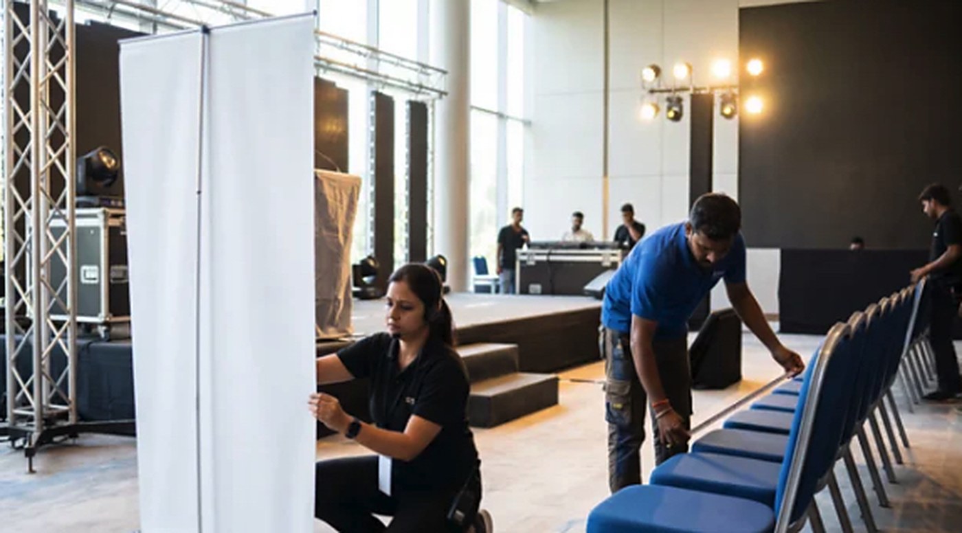 Staff setting up banners and seating in a hall before a study abroad fair.