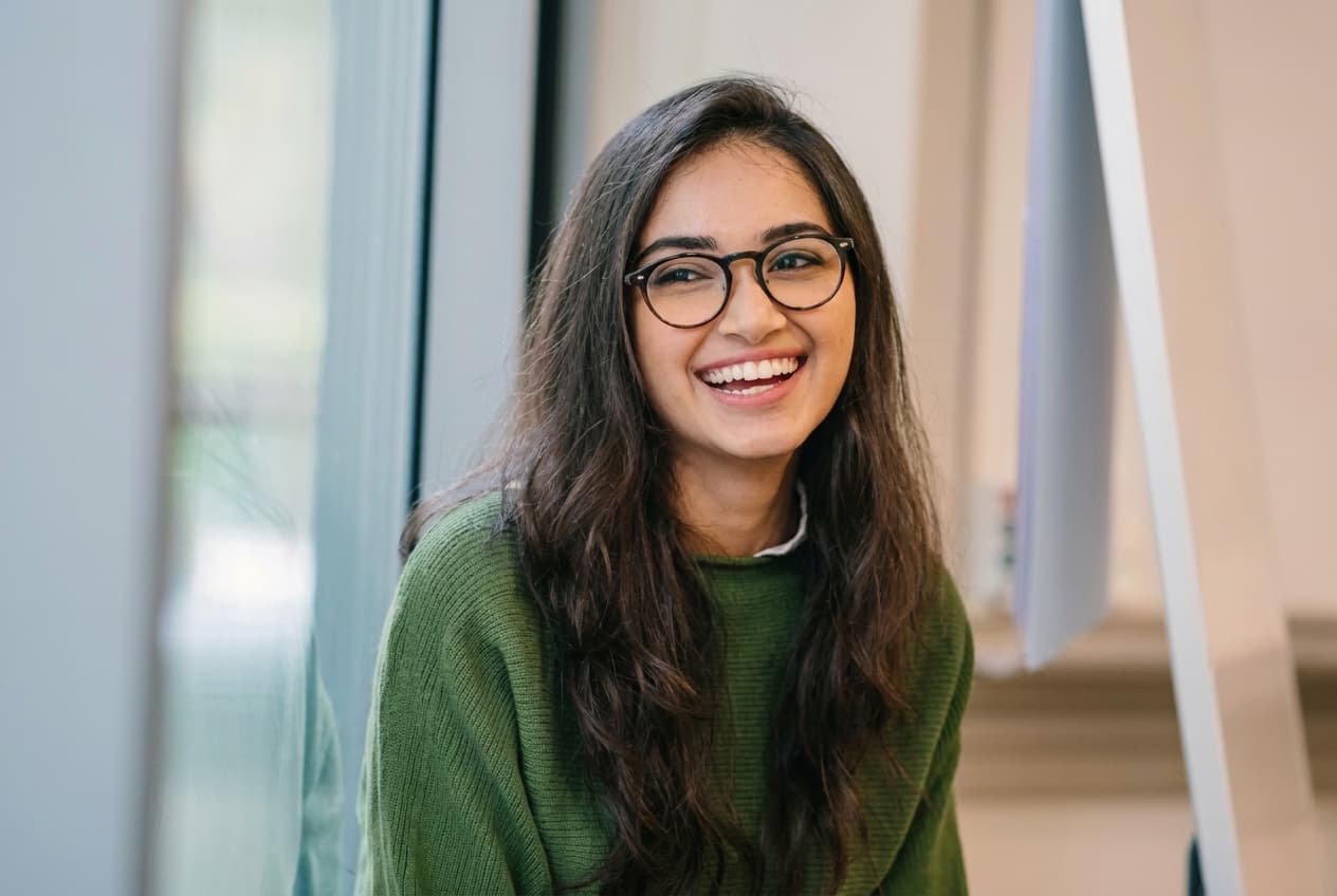 A student from India smiling while thinking through study abroad options.