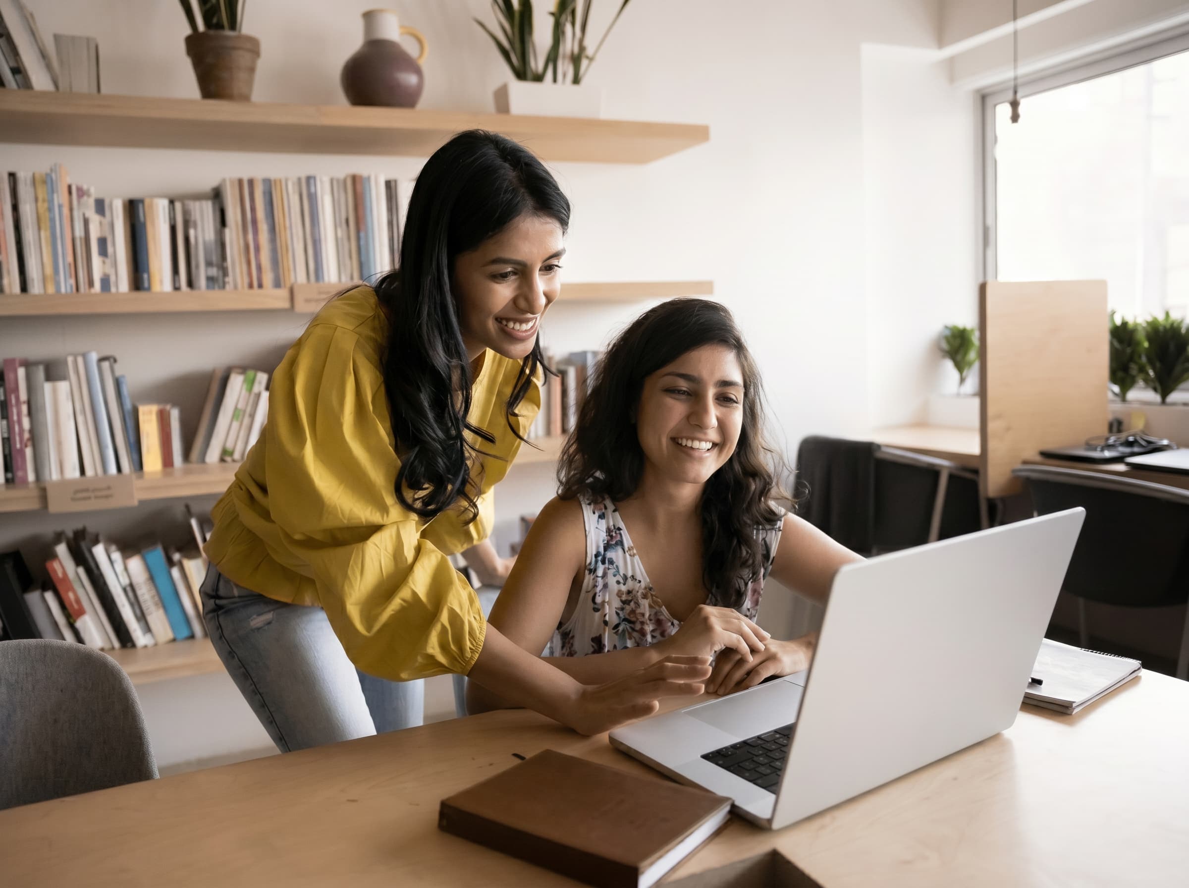 An adviser helping a student review options together on a laptop.